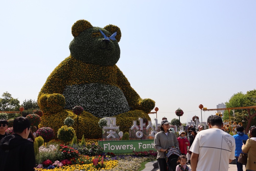 Visitors gather around a large floral sculpture at Ilsan Lake Park during the 2025 Goyang International Flower Festival.