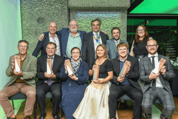 A group of award winners from the HTA Grower of the Year Awards 2025 holding trophies, with HTA President Will Armitage standing behind them.