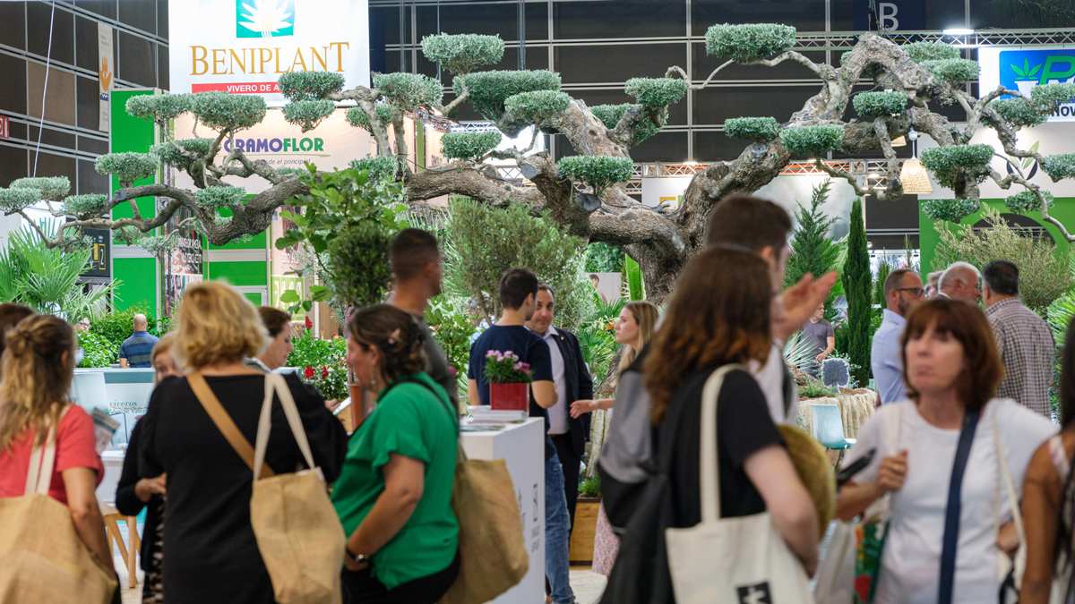Busy exhibition aisles with nursery displays and ornamental trees at Iberflora.
