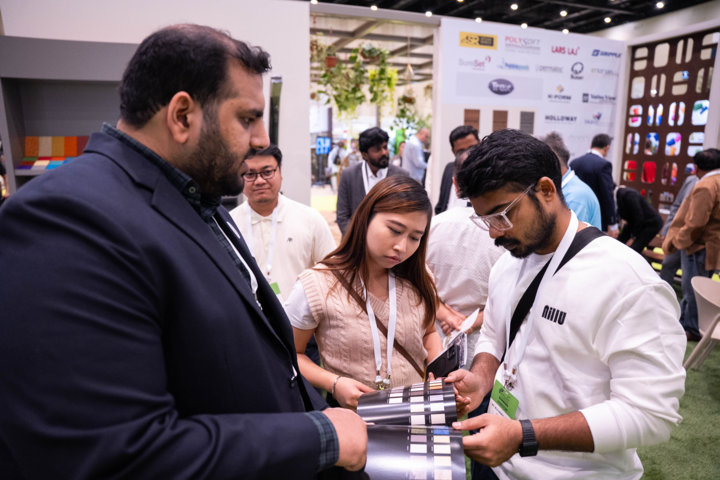 Attendees examining material samples at an exhibitor stand during Myplant & Garden Middle East.