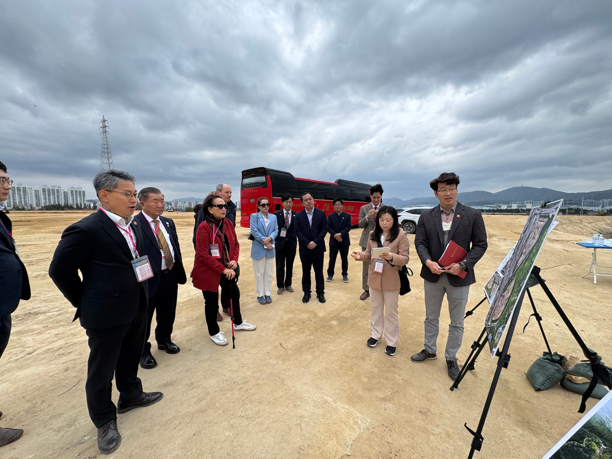 AIPH Site Inspection Team reviews site plans during outdoor inspection in Ulsan.