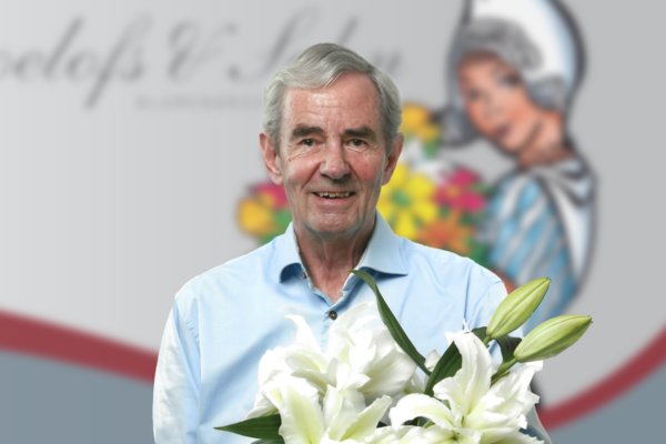 Jan Roelofs holding white lilies in front of a Roelofs Blumengrosshandel truck.