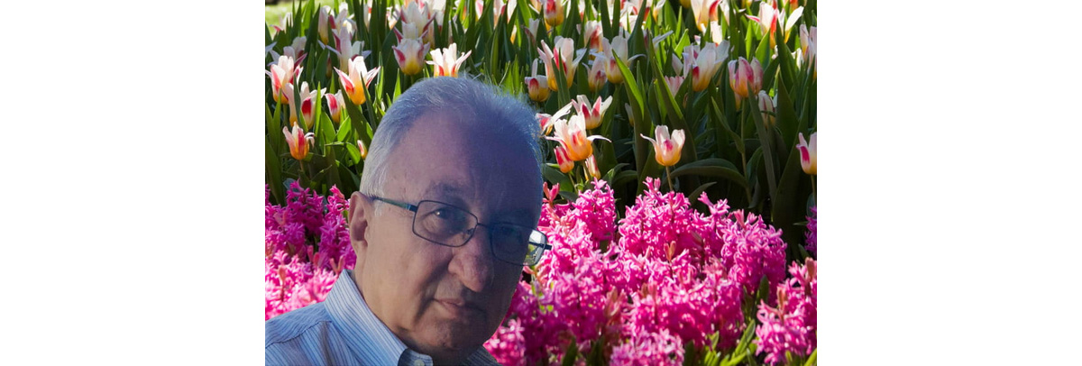 Giacomo Bruni standing in front of a display of colourful tulips and hyacinths.