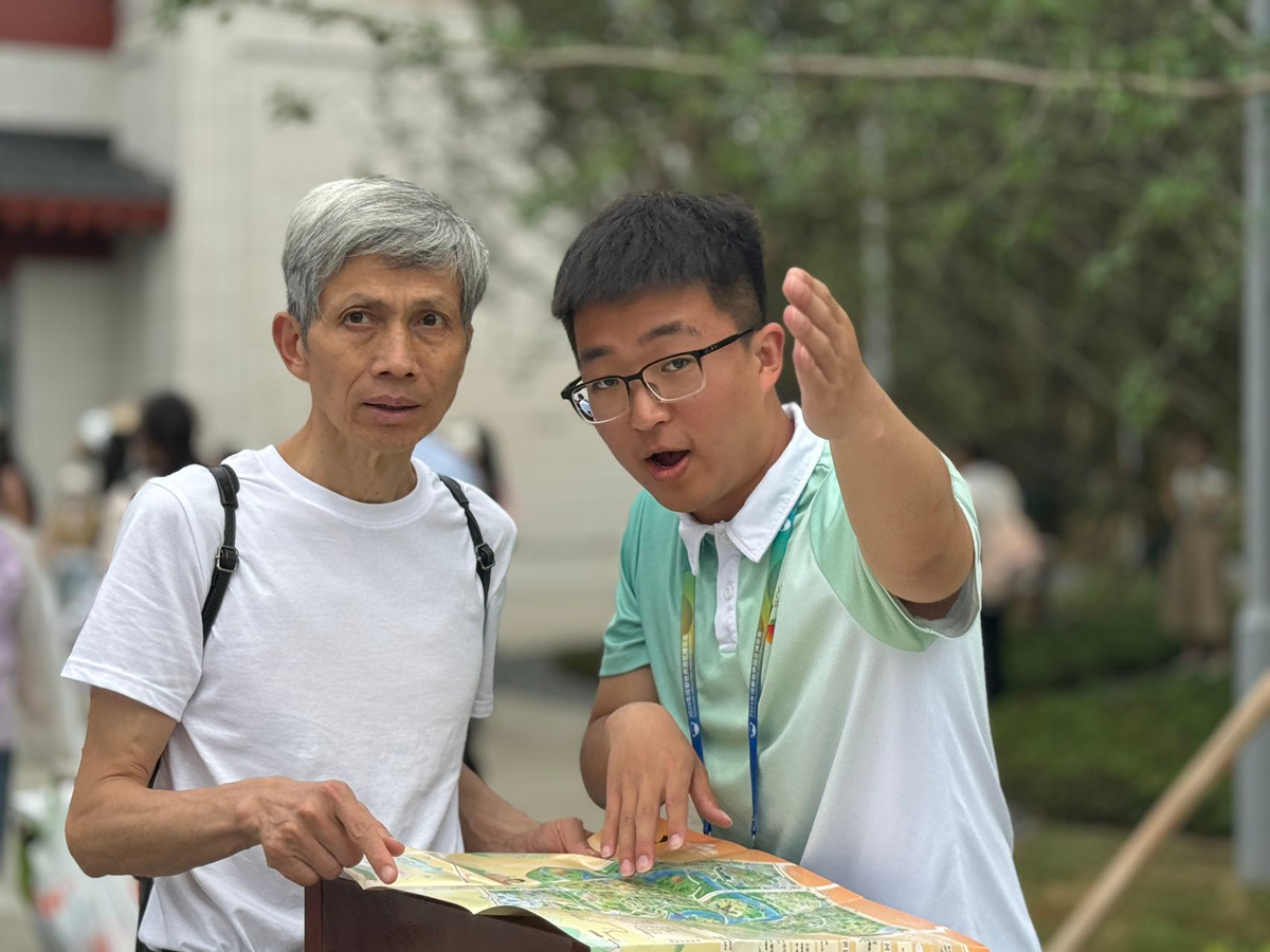 Expo volunteer helping a visitor read a site map at Expo 2024 Chengdu in China.