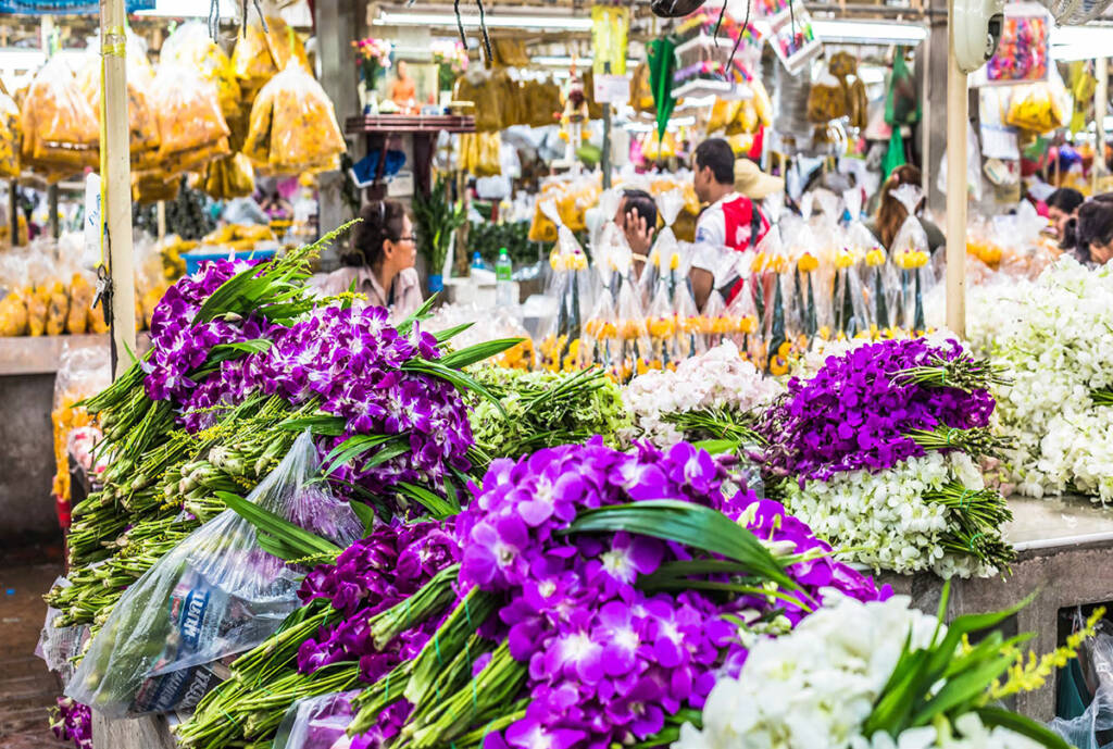 Flower market in Bangkok with orchids and fresh floral bundles for sale