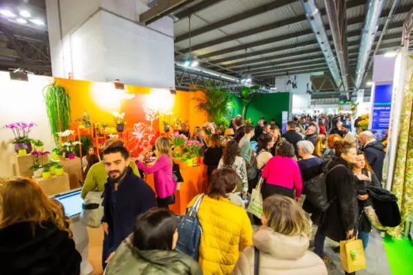 Busy exhibition aisle with visitors exploring colourful plant displays at Myplant & Garden trade fair in Milan.