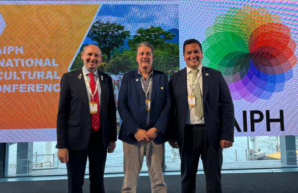 José Antonio Restrepo Rada stands with AIPH President Leonardo Capitanio and Secretary General Tim Briercliffe on stage at the AIPH International Horticultural Conference in Sydney.
