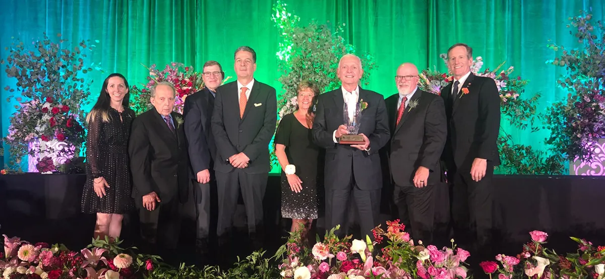 Augusto Solano Mejía holding SAF Floriculture Hall of Fame award with José Antonio Restrepo Rada and industry colleagues.