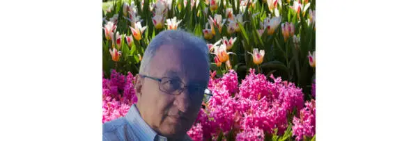 Giacomo Bruni standing in front of a display of colourful tulips and hyacinths.