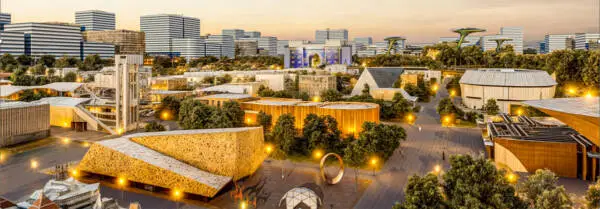 Architectural CGI of Expo 2029 Garden in Baghdad showing landscaped pavilions, pathways, and urban development at dusk.