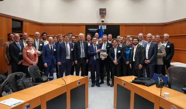 Group photo of ENA representatives and participants holding the manifesto at the European Parliament in Brussels.